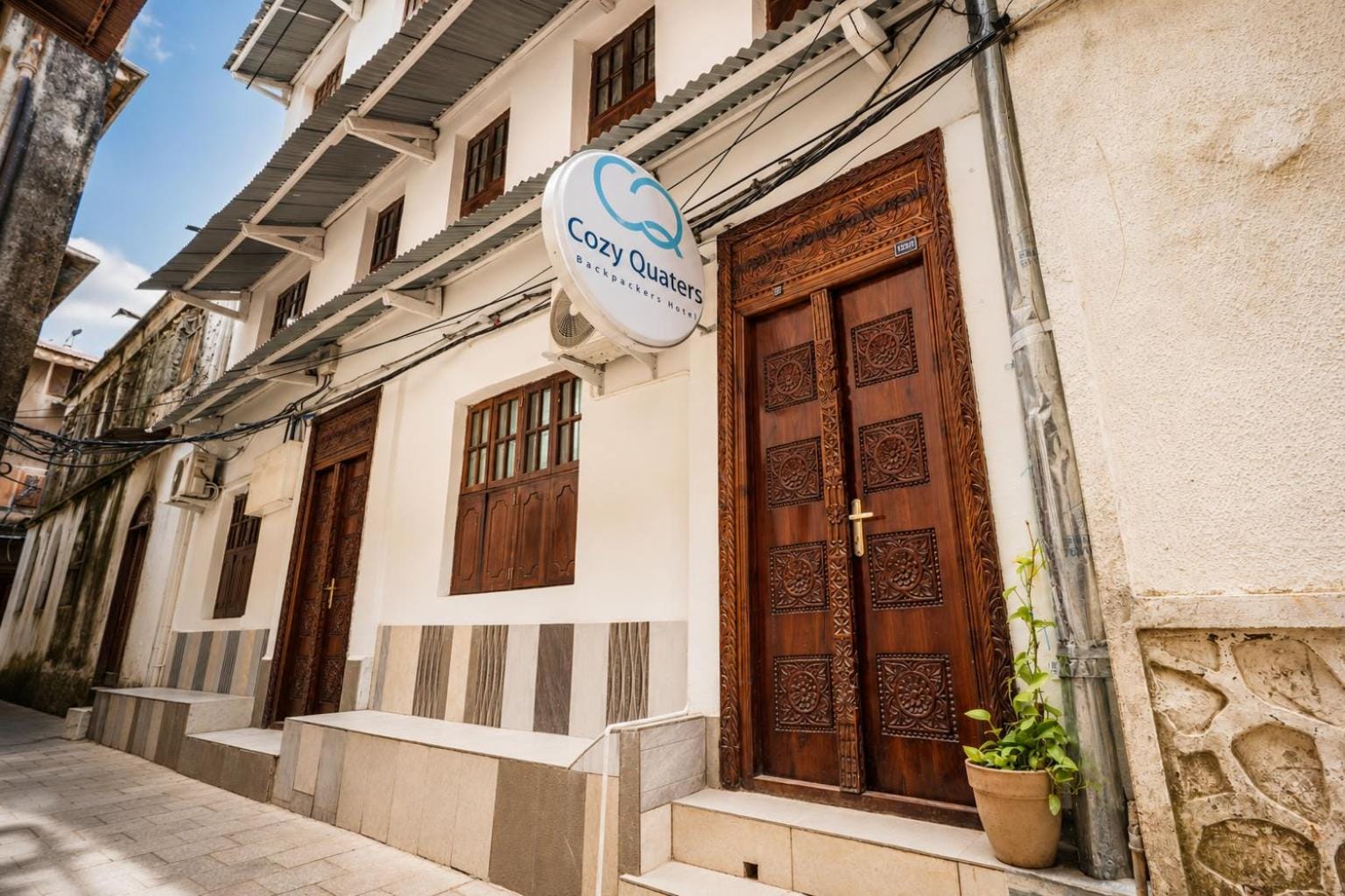 a narrow Stone Town alley of whitewashed walls and carved wooden doors