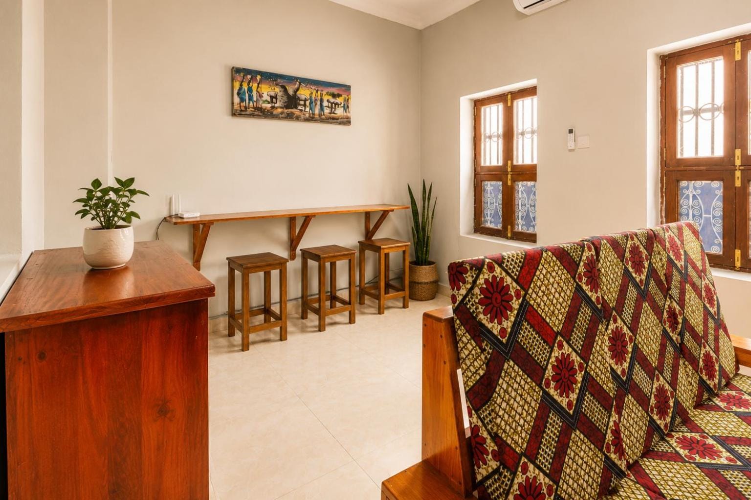 a teak bunk bed beside a long wooden counter in a whitewashed room