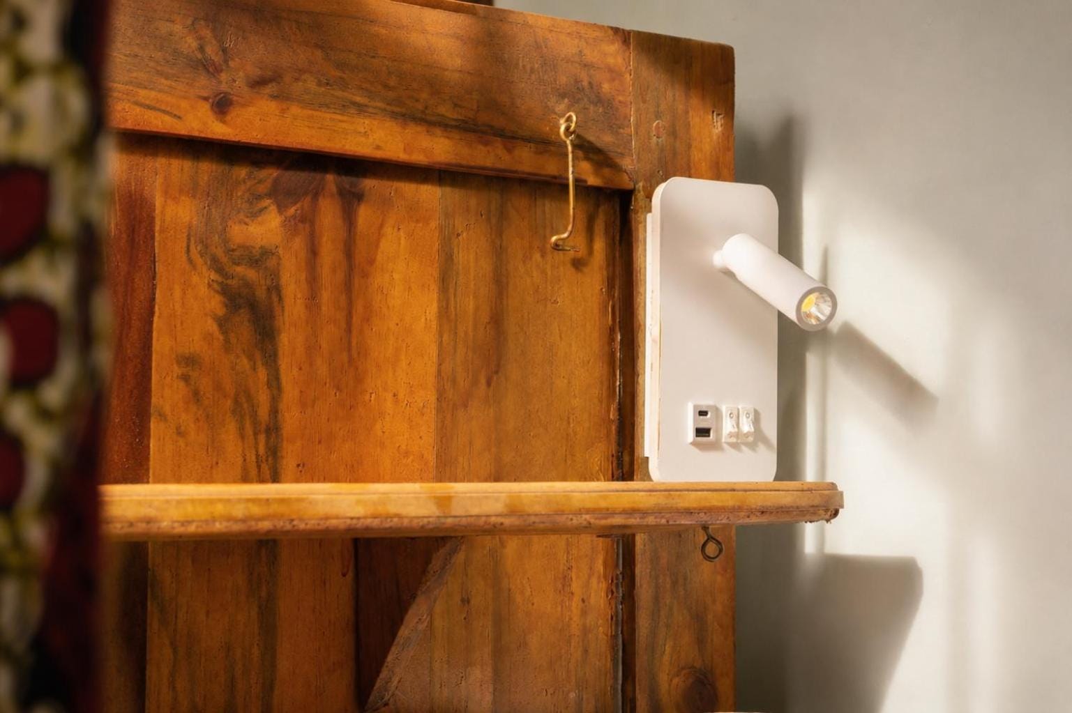 a reading light and shelf built into the head of a teak bunk