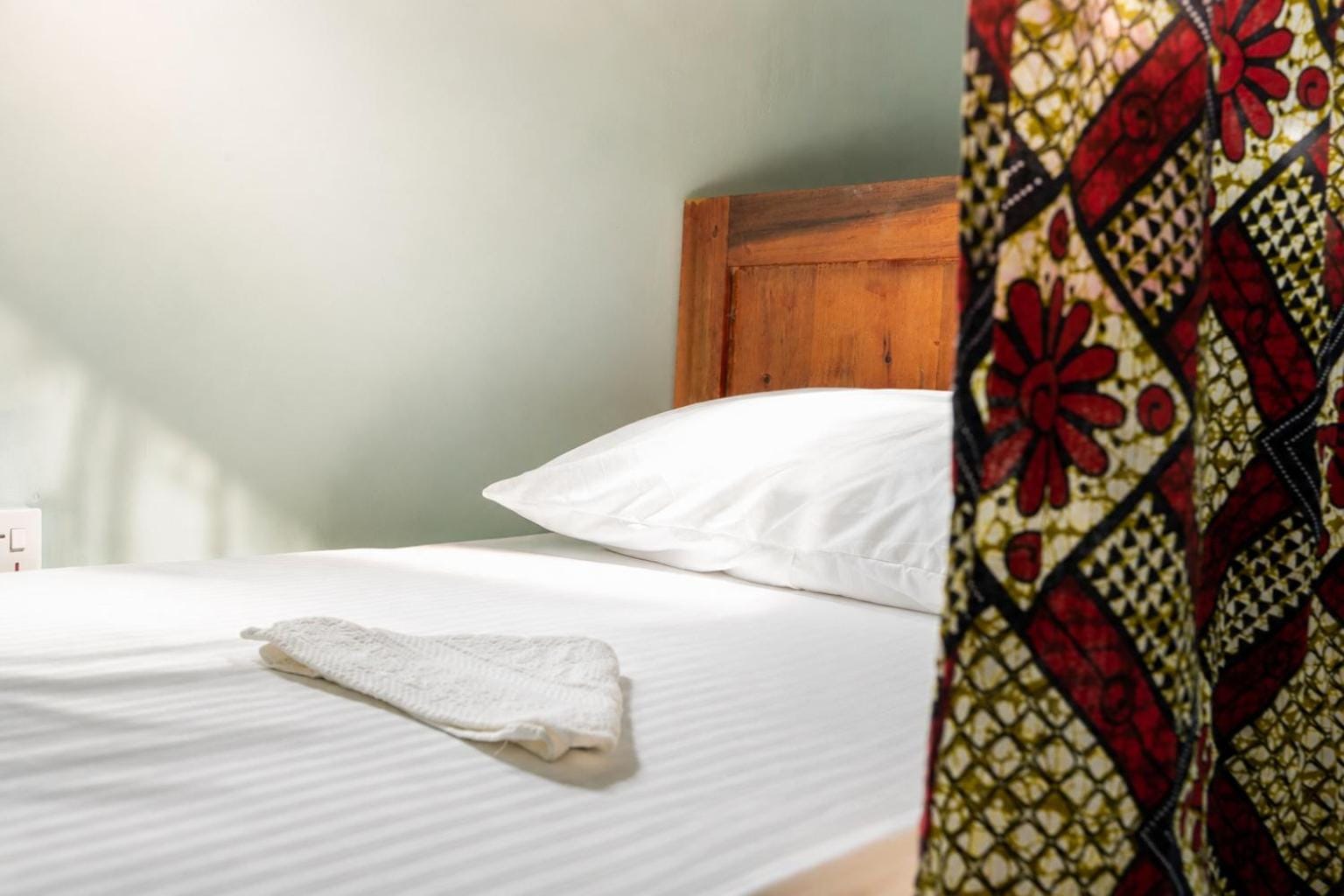 a made bunk bed with a folded towel on white linen
