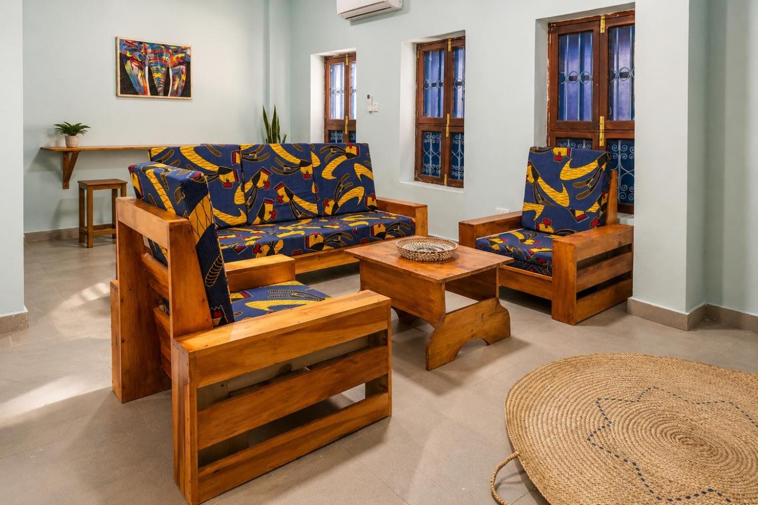 teak sofas with patterned cushions around a low table in the lounge