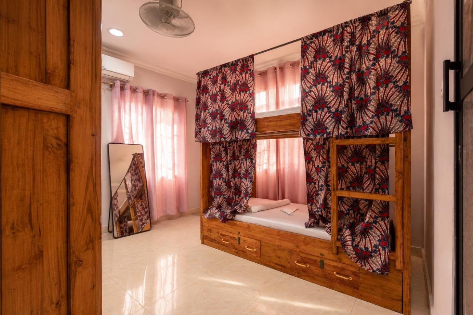 a twin room with sheer curtains and a printed bunk curtain